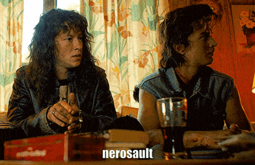 two men are sitting at a table and the word nerosault is on the screen