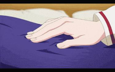 a person 's hand is touching a purple cloth