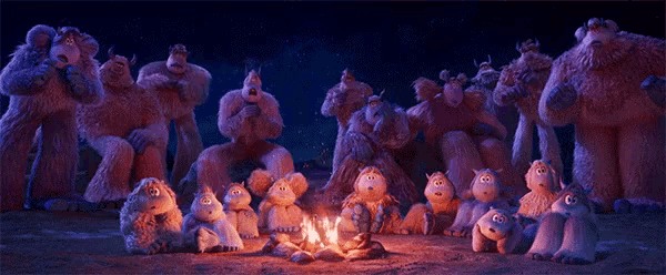 a group of stuffed animals are gathered around a campfire .