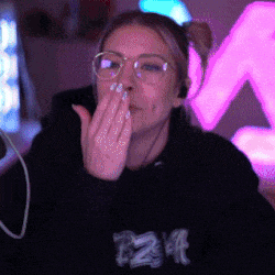 a woman wearing glasses is covering her mouth with her hand