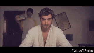 a man in a robe is sitting at a table in a room .