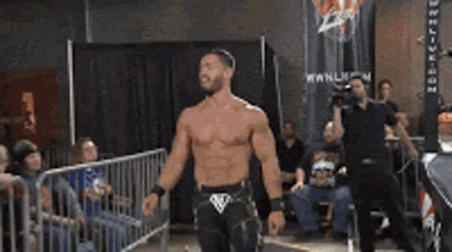 a shirtless wrestler is walking towards the crowd