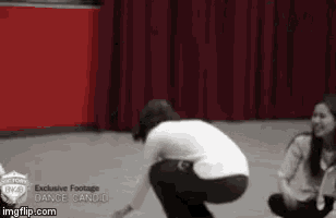 a woman squatting down in front of a red curtain with the words exclusive footage dance candi