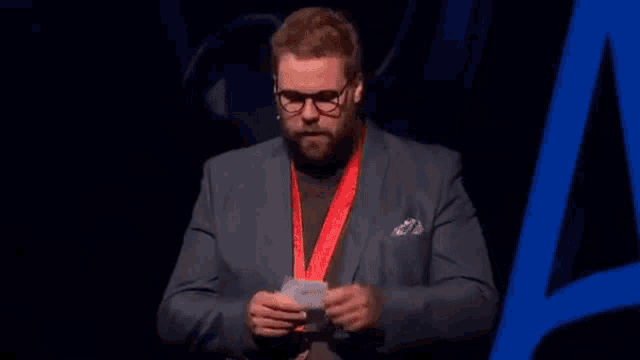 a man in a suit is holding a piece of paper that says vague job