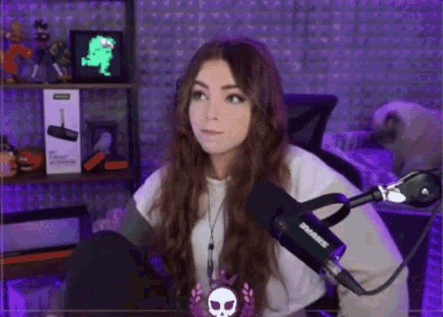 a girl sitting in front of a shure microphone