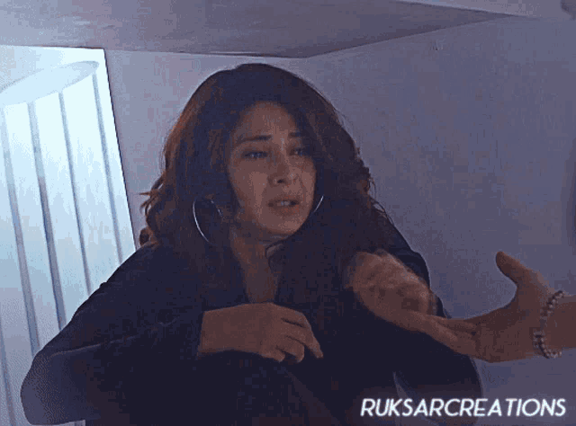 a woman in a black jacket is being held by a man with ruksarcreations written on the bottom