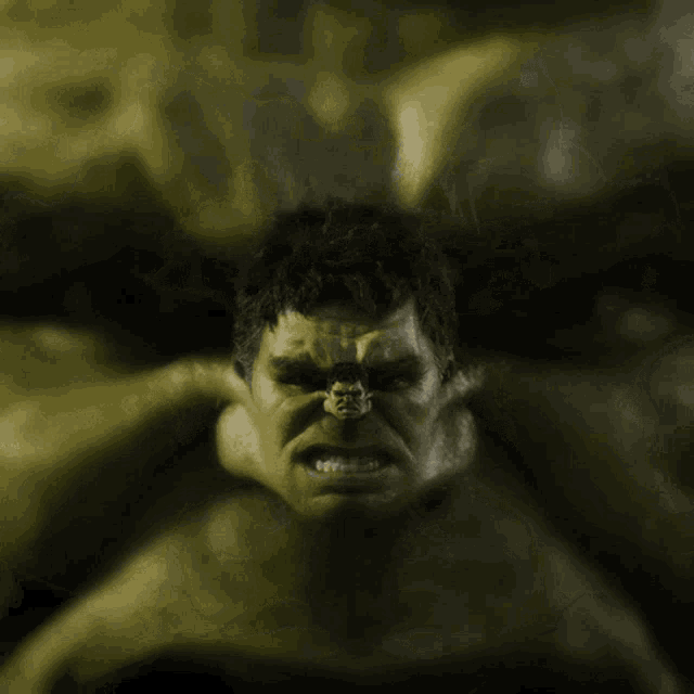 a close up of a hulk 's face with a smaller hulk in the background