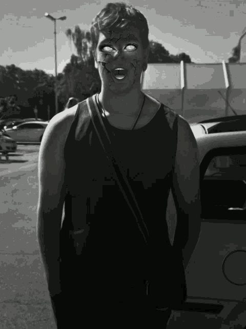 a black and white photo of a man with a scary face painted on his face