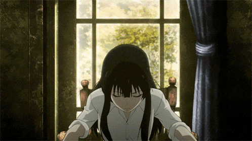 a girl with long black hair sitting in front of a window