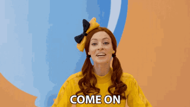 a woman in a yellow shirt says come on in front of balloons