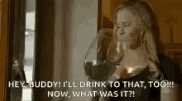 a woman is drinking a glass of wine .