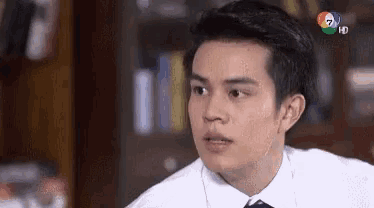 a man in a white shirt and tie is looking at something