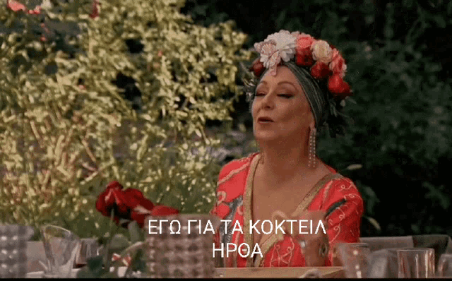 a woman with a flower crown on her head is sitting at a table with a caption in a foreign language