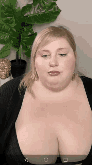 a woman with very large breasts is wearing a black sweater