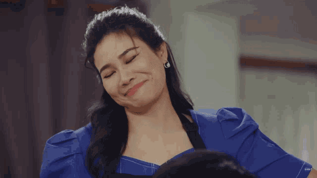 a woman in a blue dress is making a face