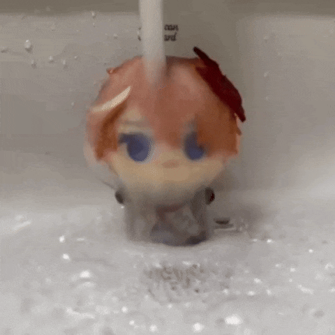 a doll is being washed in a sink with water .