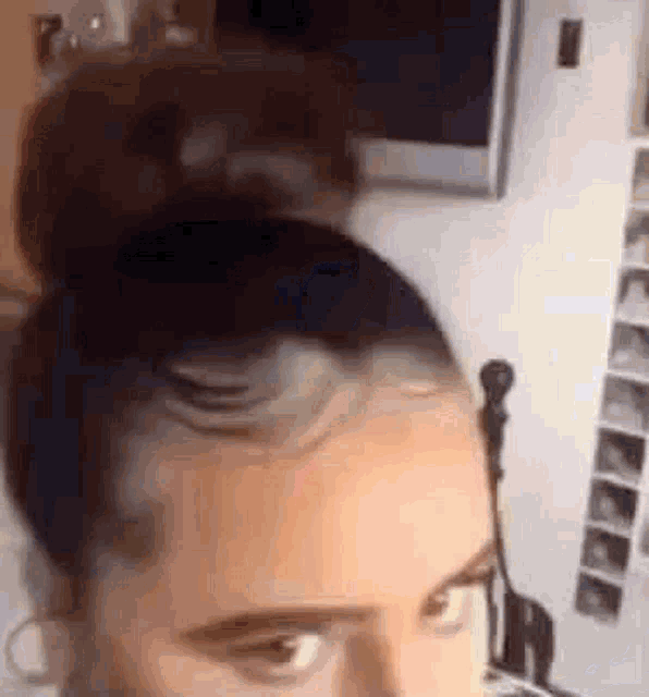 a close up of a person 's head with a bun and headphones .