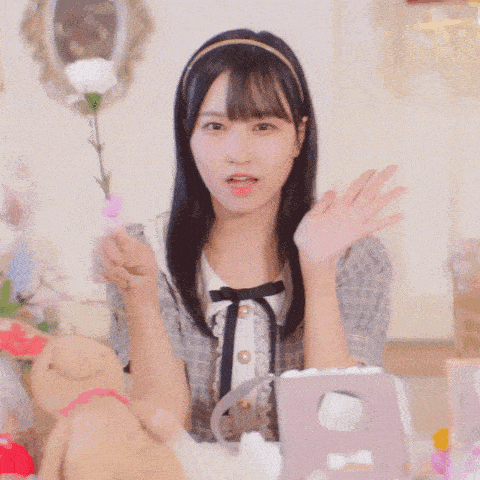 a girl is holding a flower in her hand and waving