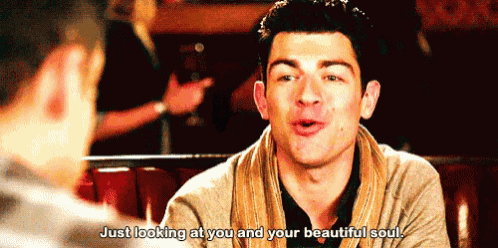 a man is sitting at a table talking to another man and says just looking at you and your beautiful soul .