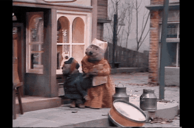 a couple of bears standing outside of a store with a sign that says ' baker ' on it