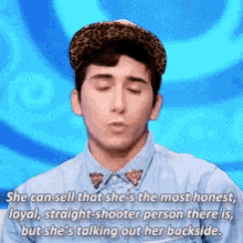 a man wearing a leopard print hat and a blue shirt is talking about a woman 's backside .