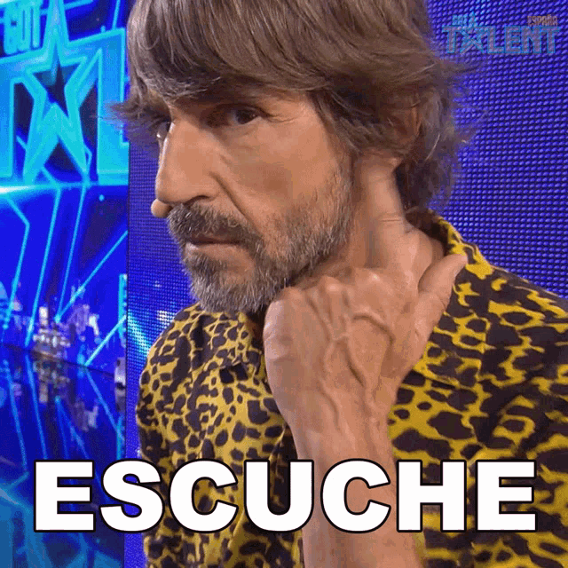 a man wearing a leopard print shirt has the word escucha written in white