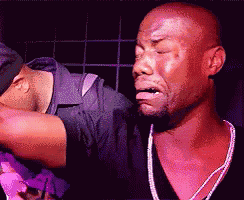 a man is crying while another man holds his hand to his face