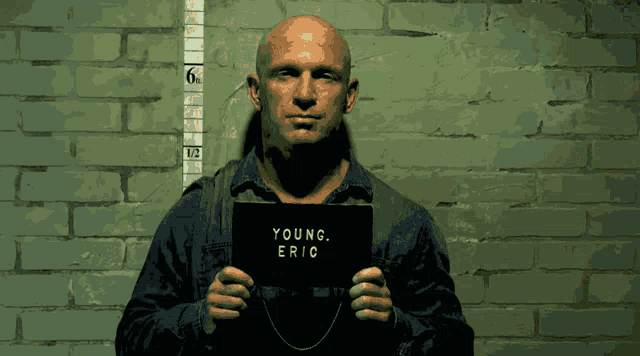 a man holding a sign that says young eric on it