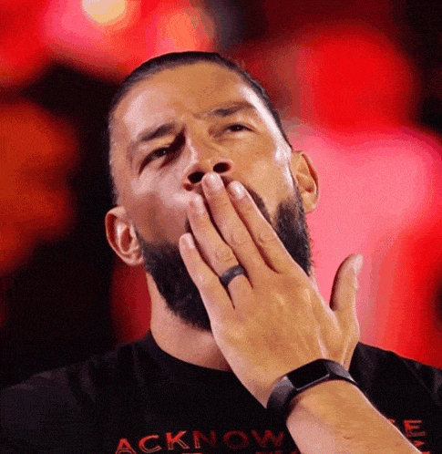 a man with a beard wears a black shirt that says acknow on it