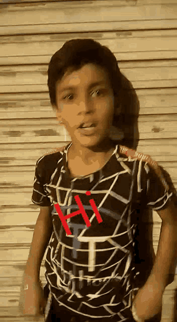 a young boy wearing a black and white shirt with the letter h on it