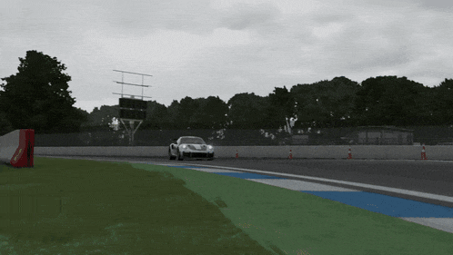 a race car is driving down a track with a coca cola sign in the background