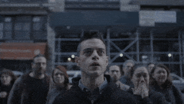 a man stands in front of a crowd looking up