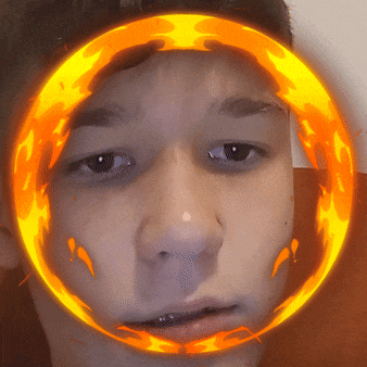 a boy 's face is surrounded by a circle of fire