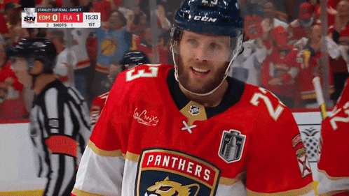 a hockey player for the panthers is smiling in front of a crowd