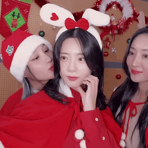 a girl wearing a santa hat and bunny ears looks at the camera