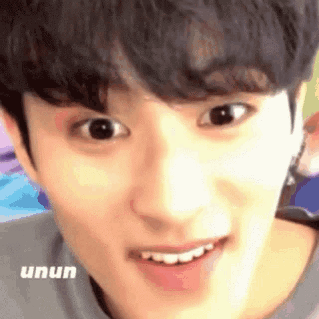 a close up of a young man 's face with his mouth open and his eyes looking at the camera .