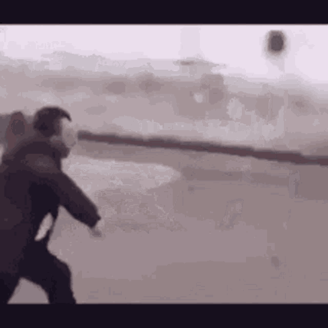 a man is standing on a runway in front of a plane .