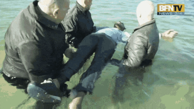 a group of men are in the water with a bfntv logo on the bottom left