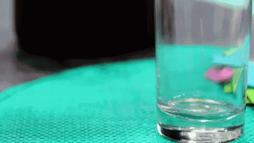 a glass of water is sitting on a green table cloth .