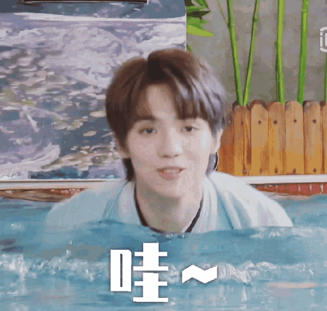 a young man is swimming in a pool with chinese characters on the bottom