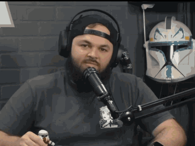a man with a beard is wearing headphones and holding a lego storm trooper