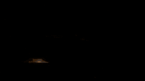 a silhouette of a person standing in front of a full moon in a dark room .