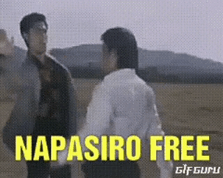 two men are standing next to each other in a field with the words napasiro free written in yellow .