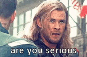a man with long hair is talking to another man and the words are you serious are on the screen .