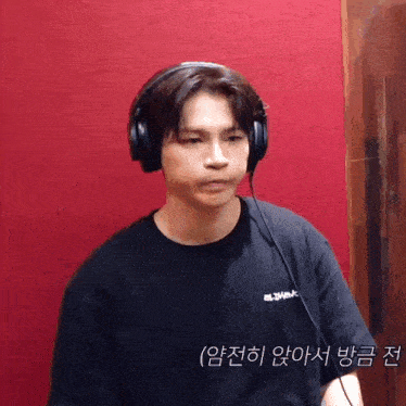 a man wearing headphones and a black t-shirt with chinese writing