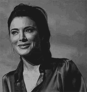 a black and white photo of a woman in a satin shirt