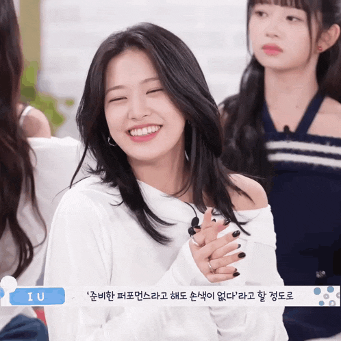 a girl in a white off the shoulder top is smiling with the word iu in the corner