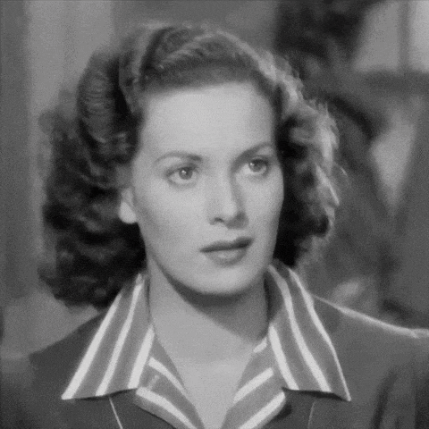 a black and white photo of a woman wearing a striped shirt and tie