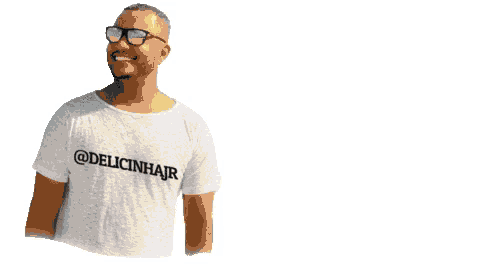 a man wearing glasses and a white shirt that says @delicinhair