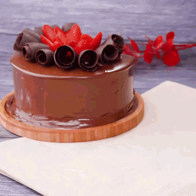 a chocolate cake with chocolate swirls and strawberries on top